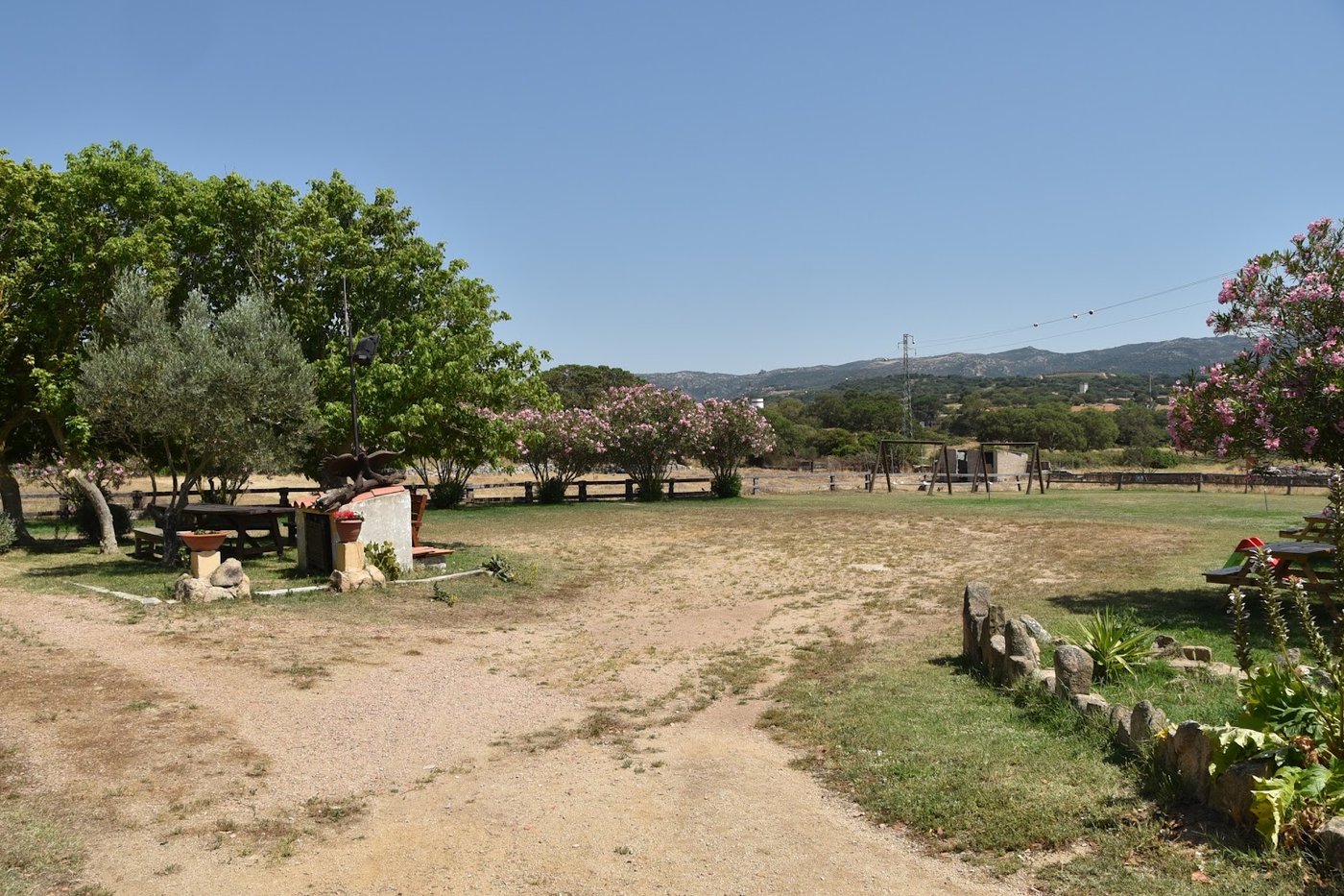 Prato e spazi all'aperto dell'agriturismo a Monti con le colline sullo sfondo
